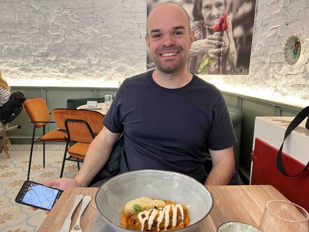 Man smiling before served Chicken Paprikas at Retek Bisztro in Budapest. 