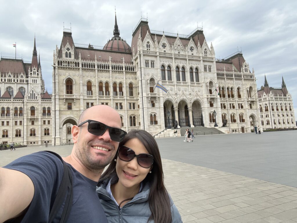  One side of the Hungarian Parliament with two people in front.